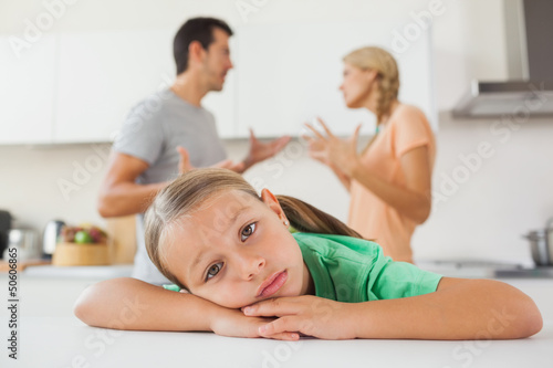 Photo: Angry couple arguing behind a sad girl Angry couple arguing behind a sad girl