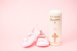Christening candle with pink baby booties and copy space