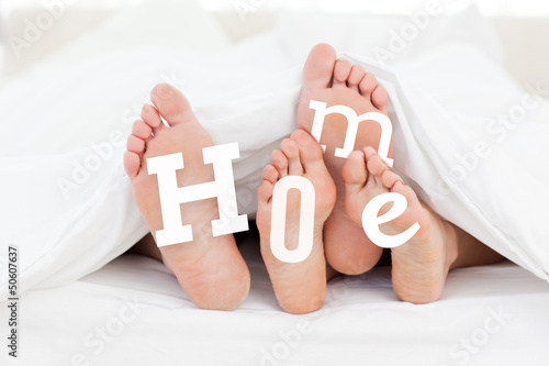 Photo: Pair of feet under the duvet with home text Pair of feet under the duvet with home text