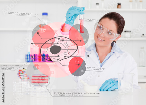 Photo: Smiling chemist looking at test tube of red chemical Smiling chemist looking at test tube of red chemical