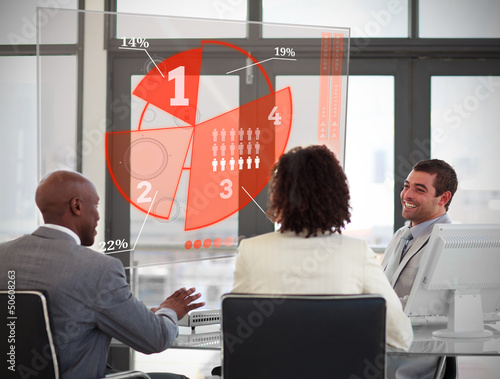 Photo: Business people using red pie chart interface Business people using red pie chart interface