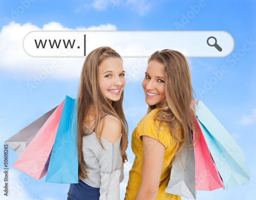Photo: Smiling girls with their shopping bags under address bar Smiling girls with their shopping bags under address bar