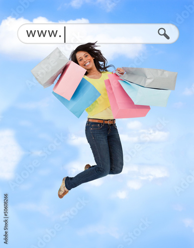 Photo: Happy girl jumping with her shopping bags under address bar Happy girl jumping with her shopping bags under address bar
