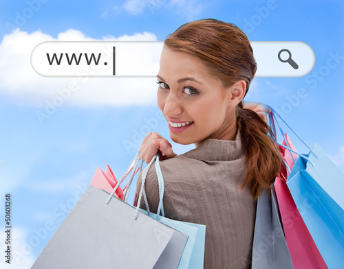 Photo: Woman looking over her shoulder with shopping bags Woman looking over her shoulder with shopping bags
