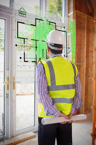 Photo: Architect looking at interface with house plan Architect looking at interface with house plan