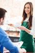 Waitress serving man at cafe