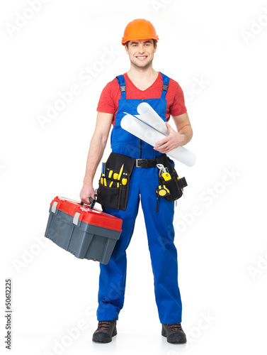 Photo: Smiling handyman with tools and paper Smiling handyman with tools and paper
