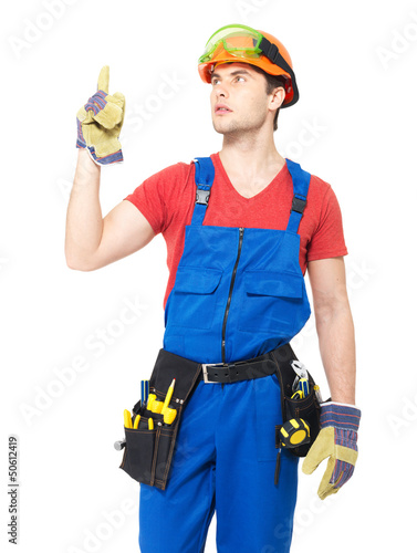 Photo: Worker with tools points up with finher Worker with tools points up with finher