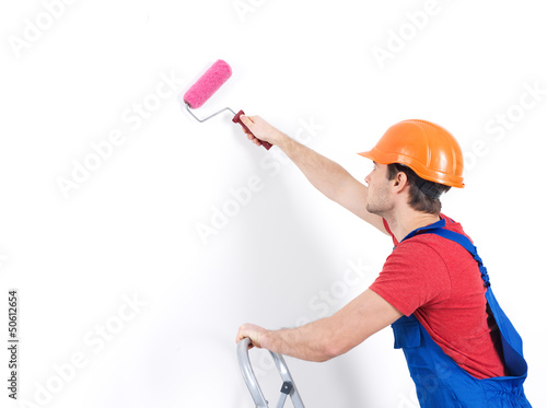 Photo: Craftsman painter stands on the stairs with roller Craftsman painter stands on the stairs with roller