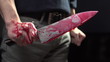 Man holding bloody knife, trembling in shock