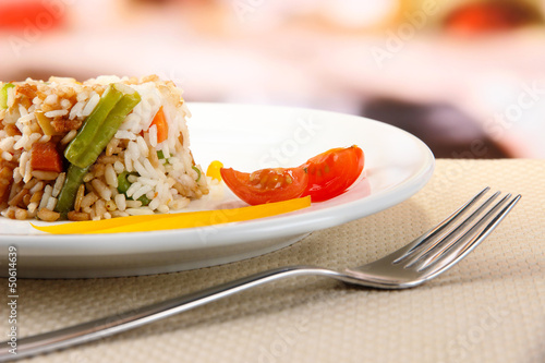Photo: Delicious risotto with vegetables on table in cafe Delicious risotto with vegetables on table in cafe