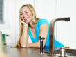 Smiling young woman stands at the kitchen counter