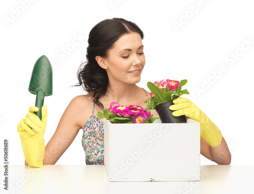 Photo: housewife with flower in pot and gardening set housewife with flower in pot and gardening set