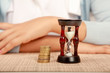 Female hand's with hourglass and coin