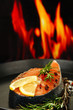 Fresh salmon steak on pan, on fire background, close up