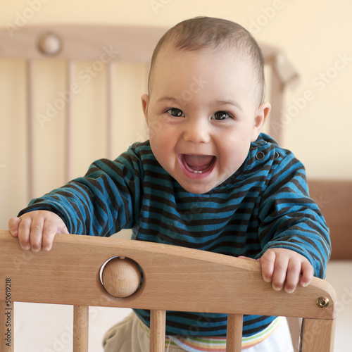 Photo: Happy baby standing in cot Happy baby standing in cot