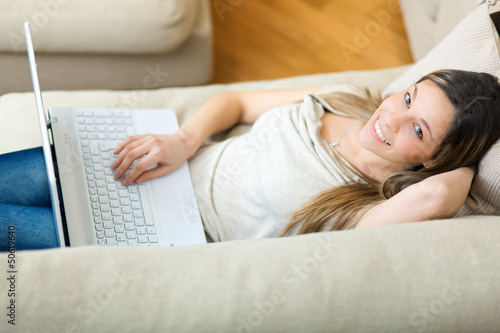 Photo: Overhead photograph of woman using laptop on sofa Overhead photograph of woman using laptop on sofa