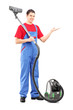 Full length portrait of a young man with a vacuum cleaner gestur