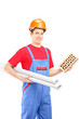 Photo: Male construction worker holding a brick and a blueprint Male construction worker holding a brick and a blueprint