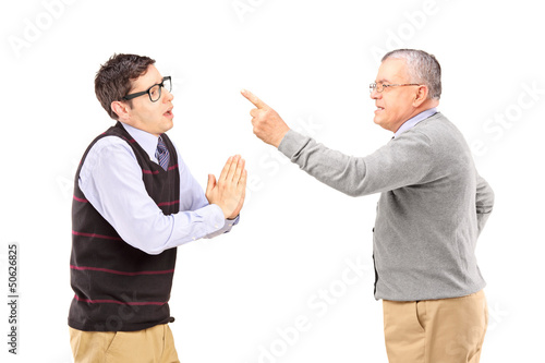 Photo: Young man begging an older angry man Young man begging an older angry man