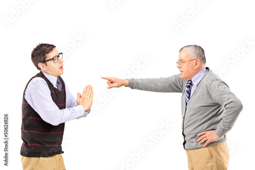 Photo: Young man begging and angry mature man gesturing with finger Young man begging and angry mature man gesturing with finger