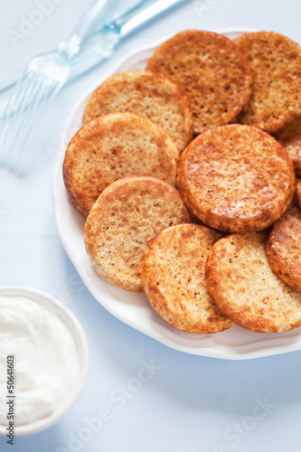 Photo: Mini pancake and sour cream, selective focus Mini pancake and sour cream, selective focus