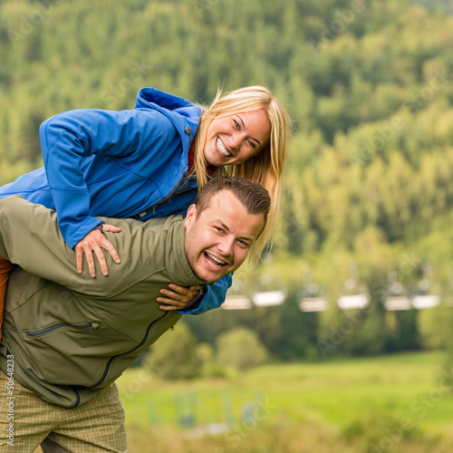 Photo: Couple having piggyback ride outside green nature Couple having piggyback ride outside green nature