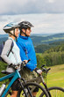 Smiling cyclists watching scenic view with bikes