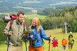 Young hiking friends reading map find track