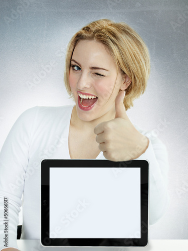 Photo: Business woman winking over her tablet pc with copyspace Business woman winking over her tablet pc with copyspace