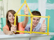 Foto: Pretty young couple in their building lot with yardstick Pretty young couple in their building lot with yardstick