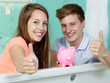 Couple sit in the bathtub of their site showing thumbs up