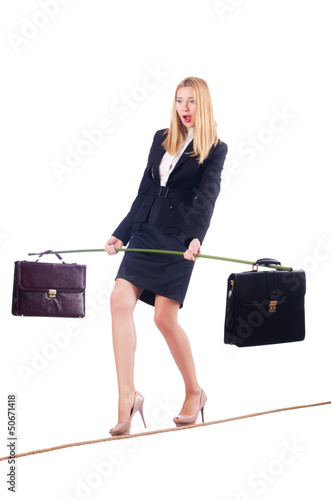 Photo: Businesswoman walking on tight rope isolated Businesswoman walking on tight rope isolated