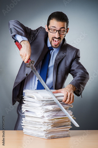 Photo: Businessman cutting the pile of paper Businessman cutting the pile of paper