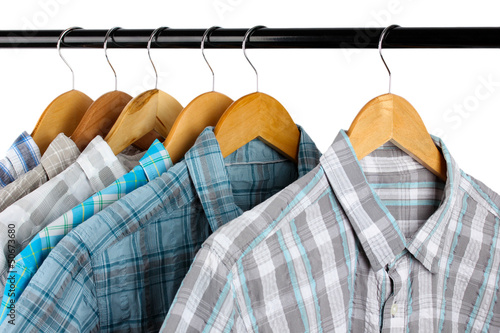Photo: Shirts with ties on wooden hangers isolated on white Shirts with ties on wooden hangers isolated on white