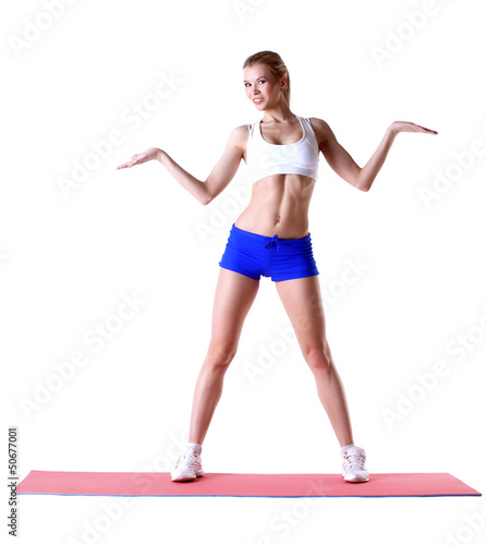 Photo: Cheerful slim woman posing on mat in studio Cheerful slim woman posing on mat in studio