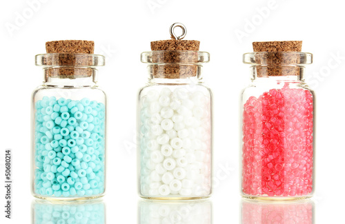 Photo: Little bottles full with colorful beads isolated on white Little bottles full with colorful beads isolated on white