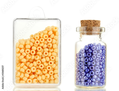 Photo: Colorful beads heap in box and glass bottle isolated on white Colorful beads heap in box and glass bottle isolated on white