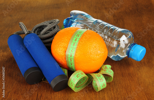 Photo: Orange with measuring tape,skipping rope and bottle of water, Orange with measuring tape,skipping rope and bottle of water,