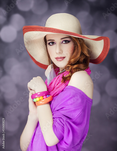 Photo: Beautiful red-haired girl in hat at bokeh background Beautiful red-haired girl in hat at bokeh background