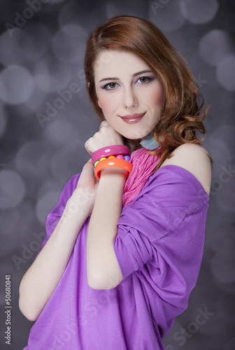 Photo: Beautiful red-haired girl at bokeh background Beautiful red-haired girl at bokeh background