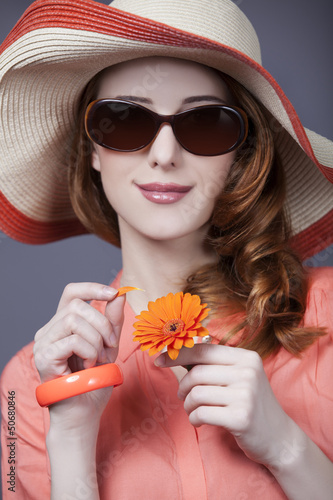 Photo: Beautiful red-haired girl in hat at white background Beautiful red-haired girl in hat at white background