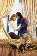 Portrait of young couple standing beside window