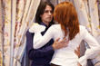 Dark-haired young man embrace young red-haired woman