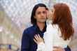 Young embracing couple - dark-haired man and red-haired woman