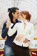 Smiling embracing young couple stands leaned on banister