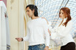 Dark-haired man with credit card and red-haired woman stand near