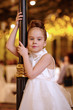 Little girl in white evening dress stands