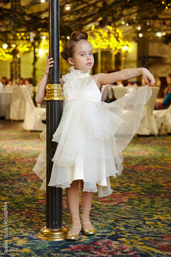 Photo: Little girl-model performs white gown, standing Little girl-model performs white gown, standing