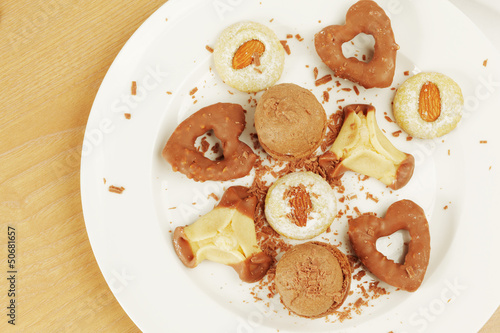 Photo: Several kinds of cookies and cakes on plate with crumbs Several kinds of cookies and cakes on plate with crumbs